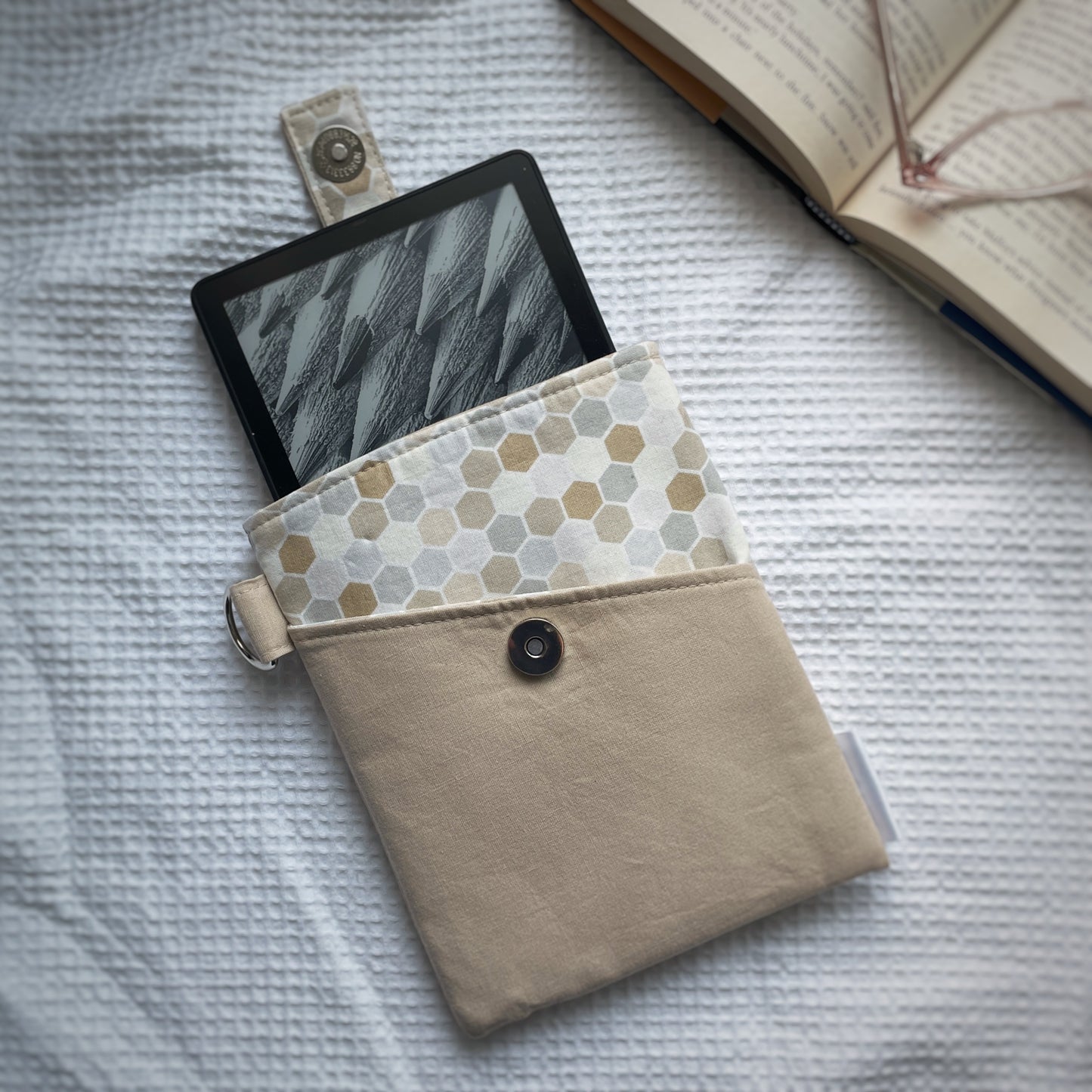 E-reader in a beige case with a patterned flap on a textured surface